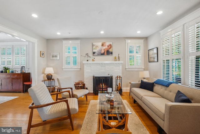 living room with recessed lighting, light wood-style flooring, and a fireplace