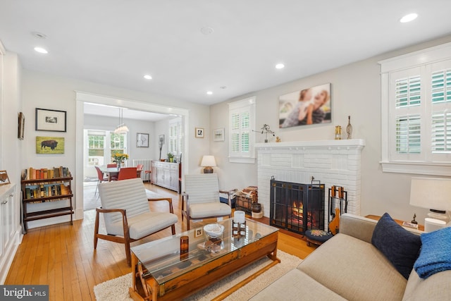 living room featuring a fireplace, recessed lighting, plenty of natural light, and light wood-style floors