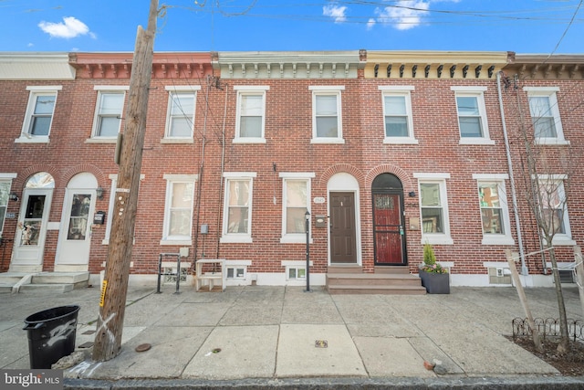 townhome / multi-family property with entry steps and brick siding