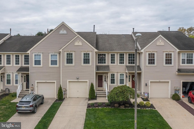 view of property with a front yard, driveway, and a garage
