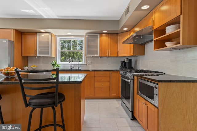 kitchen with range hood, a sink, stainless steel range with gas cooktop, a breakfast bar, and recessed lighting