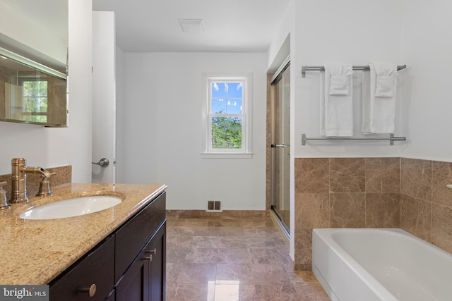full bath with a bath, vanity, and a shower stall