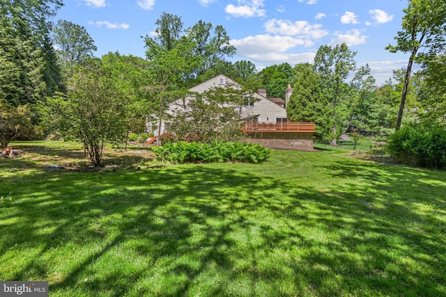 view of green lawn featuring a deck