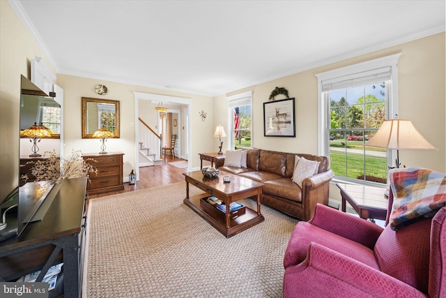 living area with stairs, ornamental molding, and wood finished floors