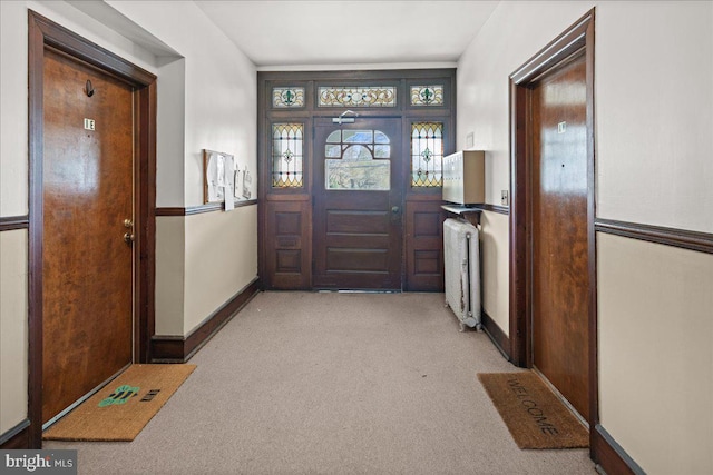 carpeted entrance foyer featuring baseboards and radiator
