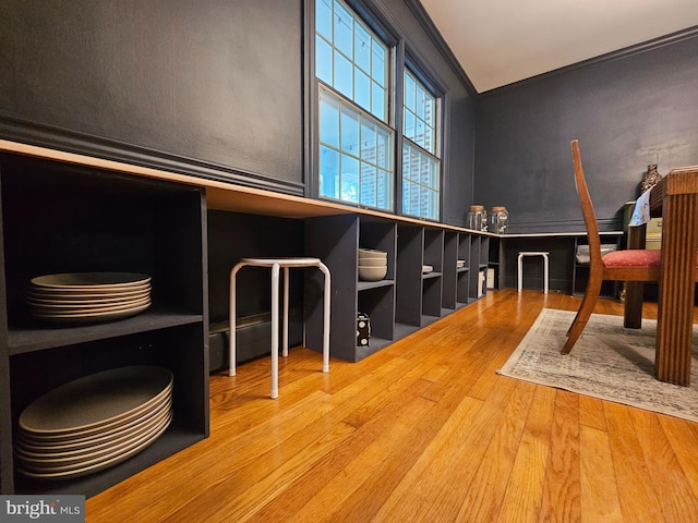 interior space with crown molding, vaulted ceiling, and wood finished floors