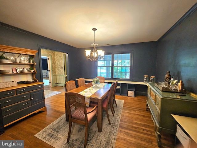 dining room with crown molding, a chandelier, and dark wood-style floors