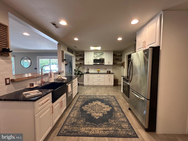 kitchen featuring visible vents, open shelves, white cabinetry, a sink, and stainless steel appliances