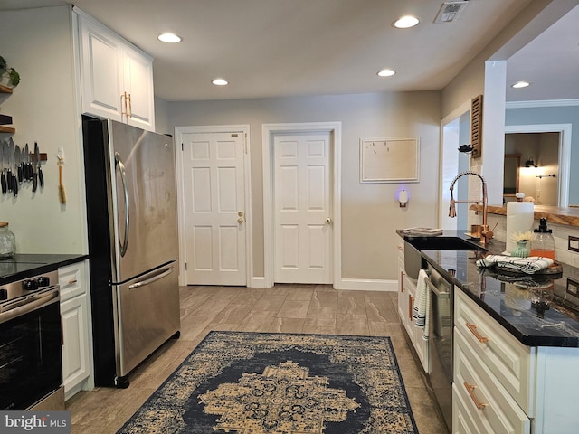 kitchen with visible vents, freestanding refrigerator, recessed lighting, white cabinetry, and oven