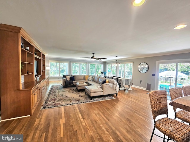 living room featuring baseboards, ornamental molding, and wood finished floors