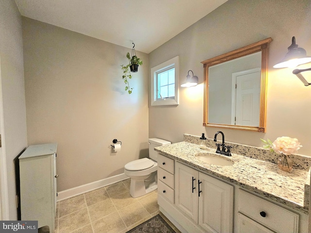 bathroom with toilet, baseboards, and vanity