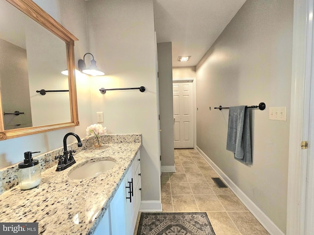 bathroom with baseboards, vanity, tile patterned floors, and visible vents