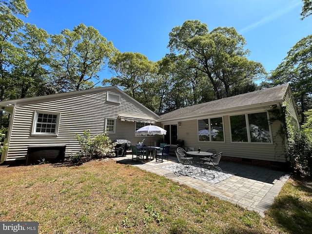 rear view of house featuring a lawn, a patio, and crawl space