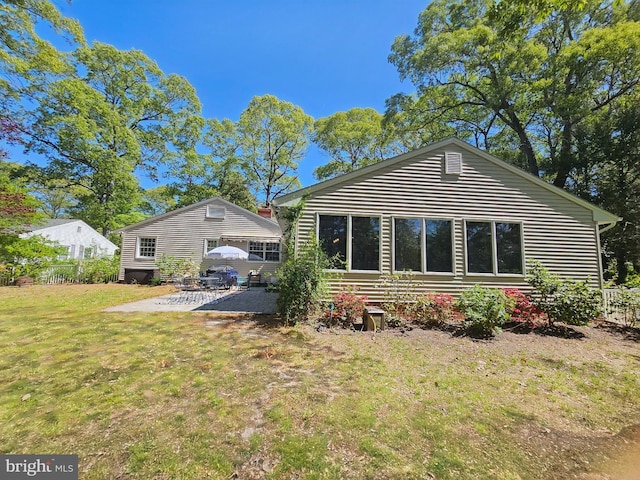 back of property with a patio and a yard