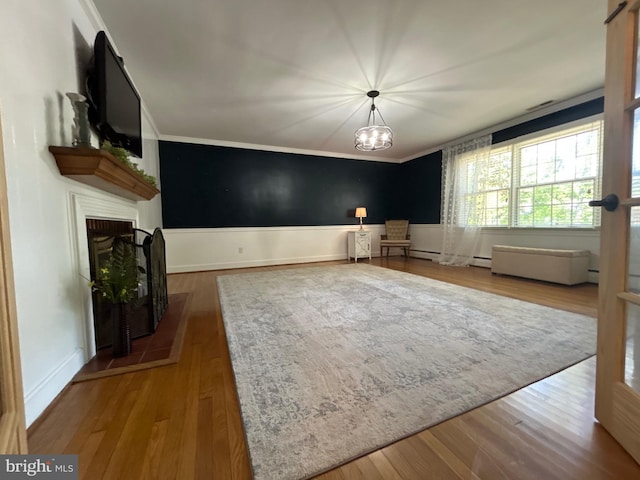 unfurnished living room featuring baseboards, ornamental molding, wood finished floors, and a fireplace