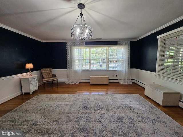 interior space featuring crown molding, wood finished floors, a wainscoted wall, and an inviting chandelier