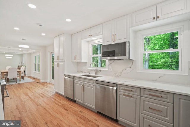kitchen featuring a sink, gray cabinetry, stainless steel appliances, and a wealth of natural light