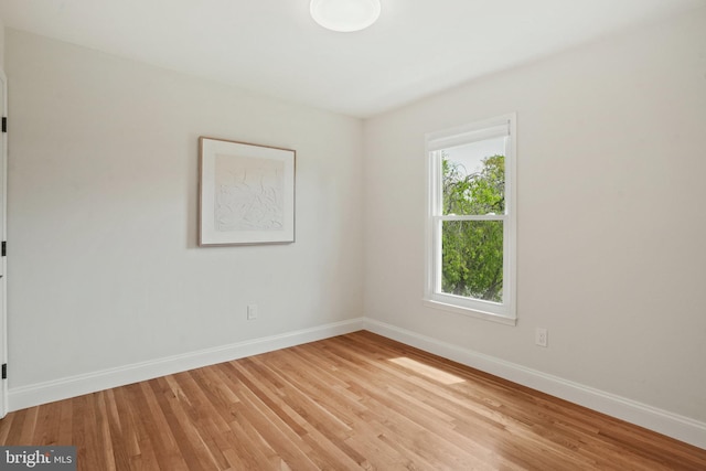 unfurnished room featuring baseboards and light wood-style flooring