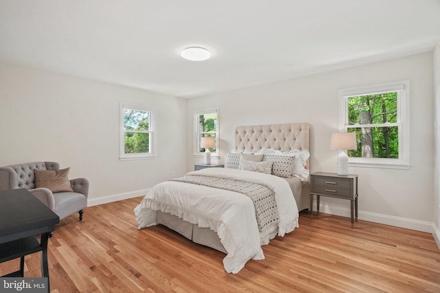 bedroom with baseboards and light wood finished floors
