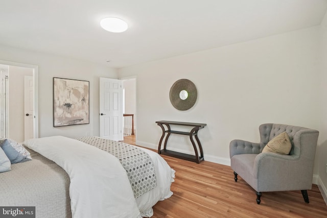 bedroom with baseboards and light wood finished floors