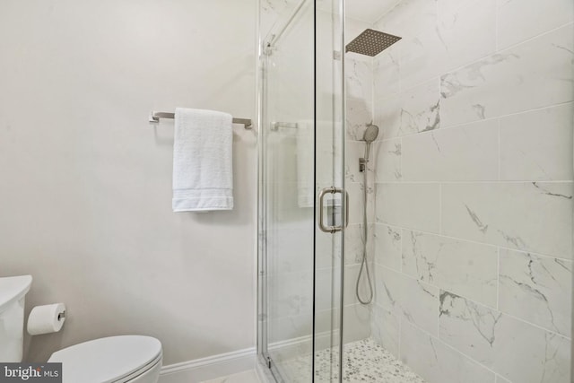 full bathroom with toilet, baseboards, and a stall shower