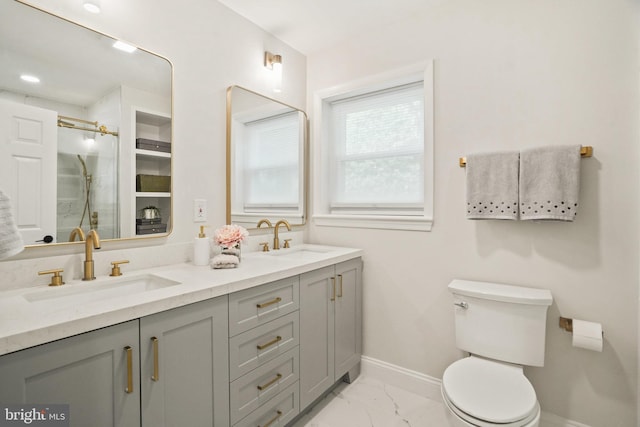 full bath with a sink, toilet, marble finish floor, baseboards, and a shower stall