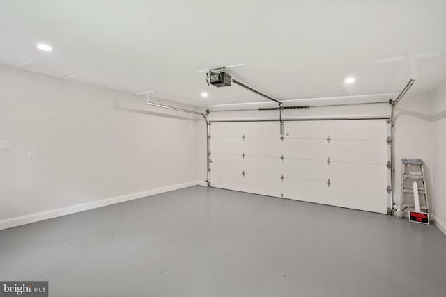 garage featuring baseboards, a garage door opener, and recessed lighting