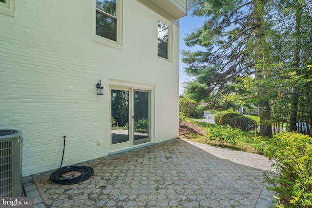 exterior space with brick siding, a patio area, and central air condition unit