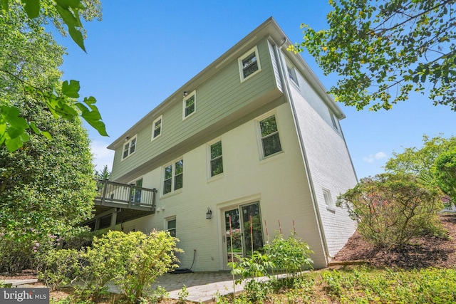 rear view of property featuring a patio and a deck