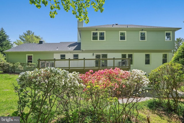 rear view of house featuring a wooden deck and a chimney