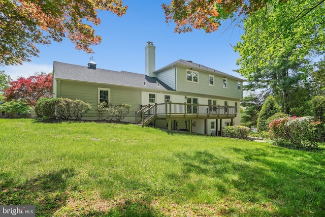 back of property featuring a chimney, stairs, a yard, and a deck