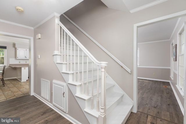 stairs featuring ornamental molding, visible vents, and wood finished floors