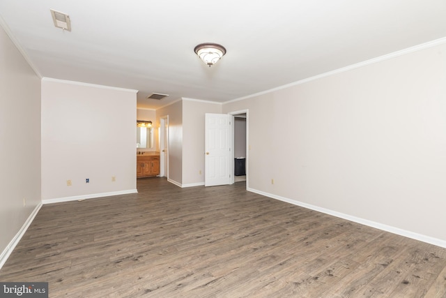 empty room featuring wood finished floors, visible vents, and baseboards