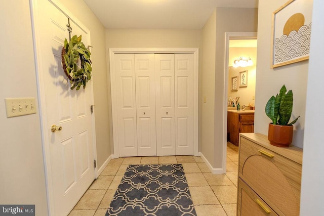 interior space featuring light tile patterned flooring and baseboards