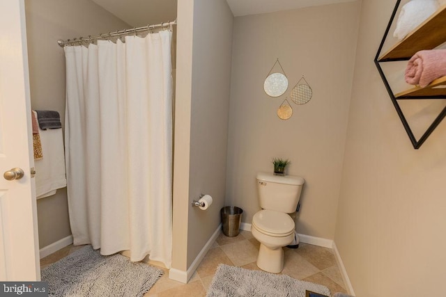 bathroom featuring tile patterned floors, toilet, a shower with curtain, and baseboards