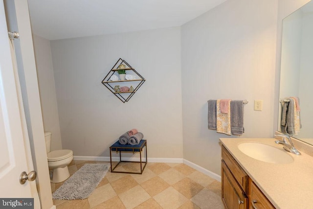 bathroom featuring baseboards, toilet, and vanity