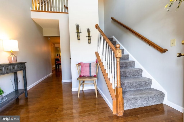 stairs featuring wood finished floors and baseboards