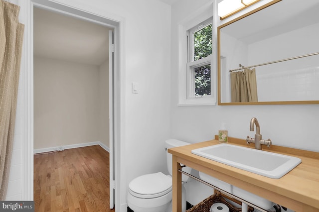 9235 E Parkhill Dr, Bethesda, MD 20814 - full bath with toilet, wood finished floors, vanity, curtained shower, and baseboards