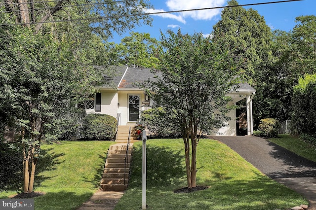 9235 E Parkhill Dr, Bethesda, MD 20814 - view of property hidden behind natural elements with asphalt driveway, a front yard, brick siding, and a shingled roof