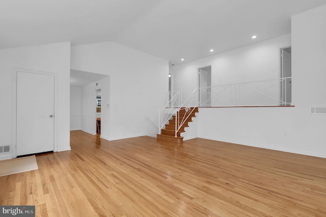 9235 E Parkhill Dr, Bethesda, MD 20814 - empty room with light wood-style flooring, stairway, vaulted ceiling, and recessed lighting