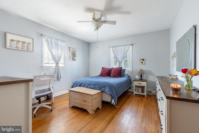 bedroom with baseboards, a ceiling fan, light wood-style flooring, and visible vents