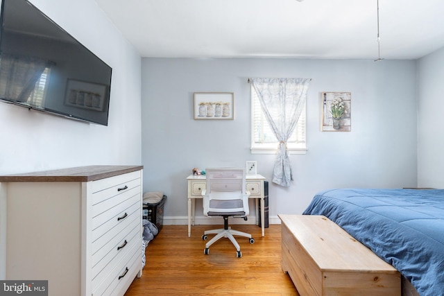 bedroom featuring baseboards and light wood finished floors