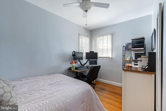 bedroom with baseboards, ceiling fan, and wood finished floors