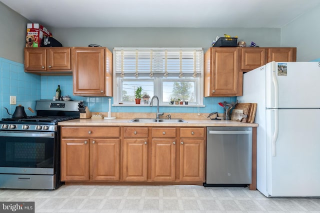 kitchen with light countertops, a sink, brown cabinets, and stainless steel appliances