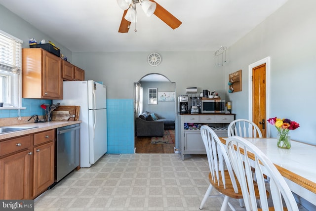 kitchen featuring brown cabinetry, light countertops, appliances with stainless steel finishes, and ceiling fan