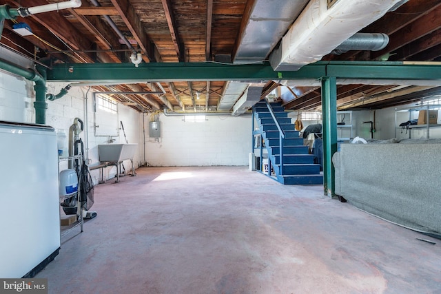 unfinished basement with stairs, fridge, a sink, and electric panel