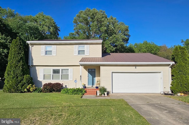 view of front facade with driveway, a front yard, a garage, and metal roof