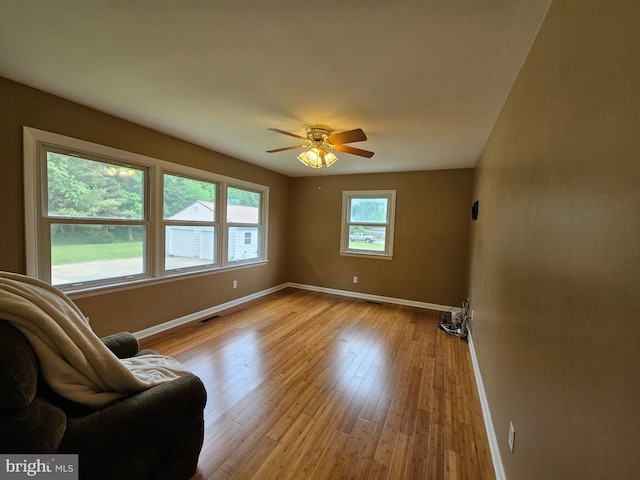 sitting room featuring baseboards, ceiling fan, and hardwood / wood-style floors