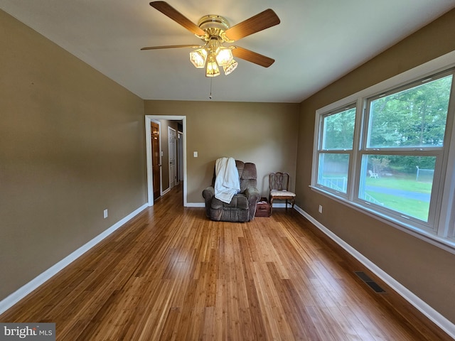 sitting room featuring wood finished floors, baseboards, and a ceiling fan