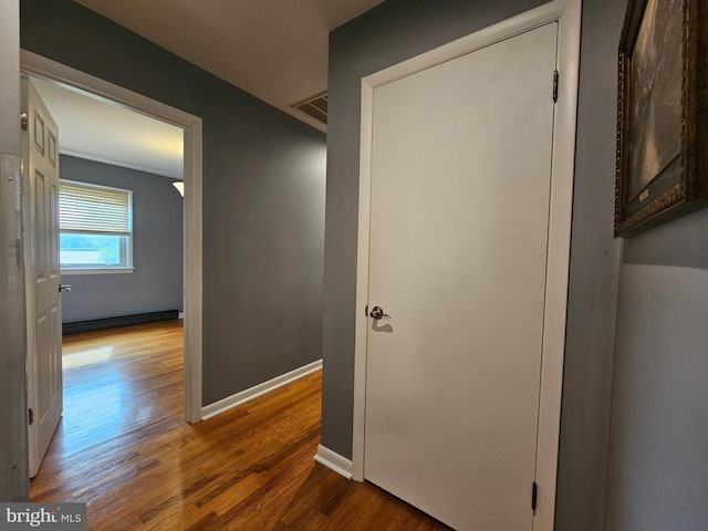 corridor featuring wood finished floors and baseboards